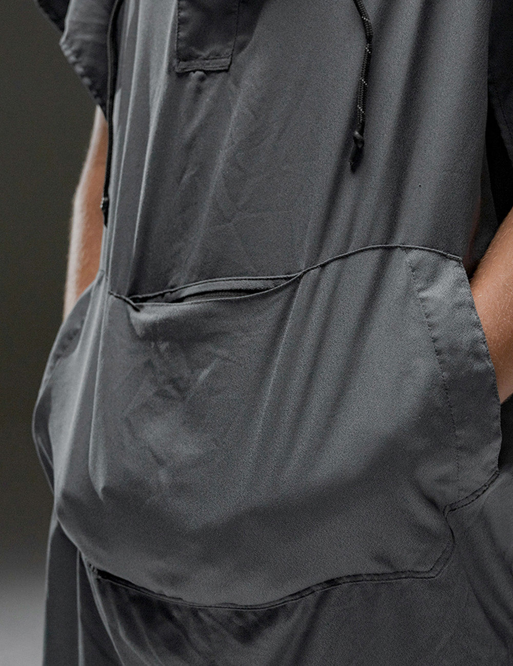person with hands in kangaroo pocket of poncho