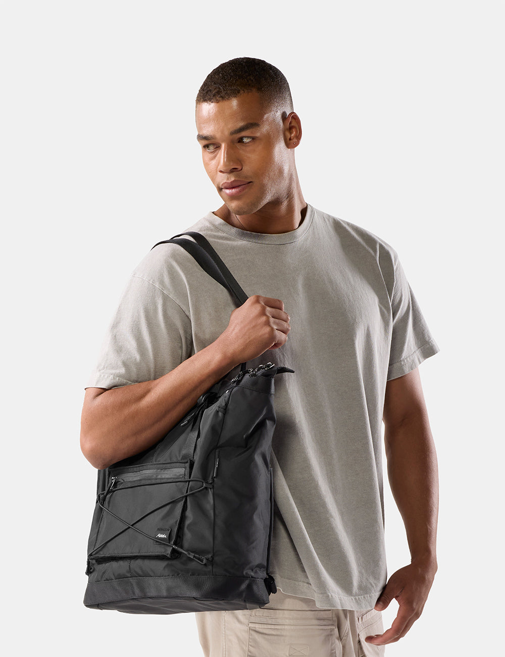 person carrying black tote bag on white background