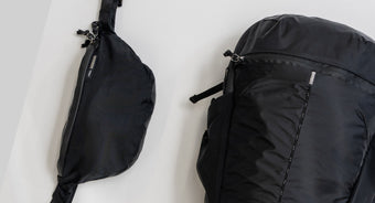 black sling and backpack on white background