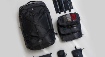 backpack and travel accessories on light gray background