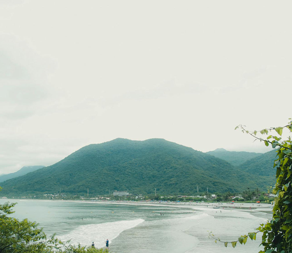 Beach with mountains in the background on a cloudy summer day in Brazil