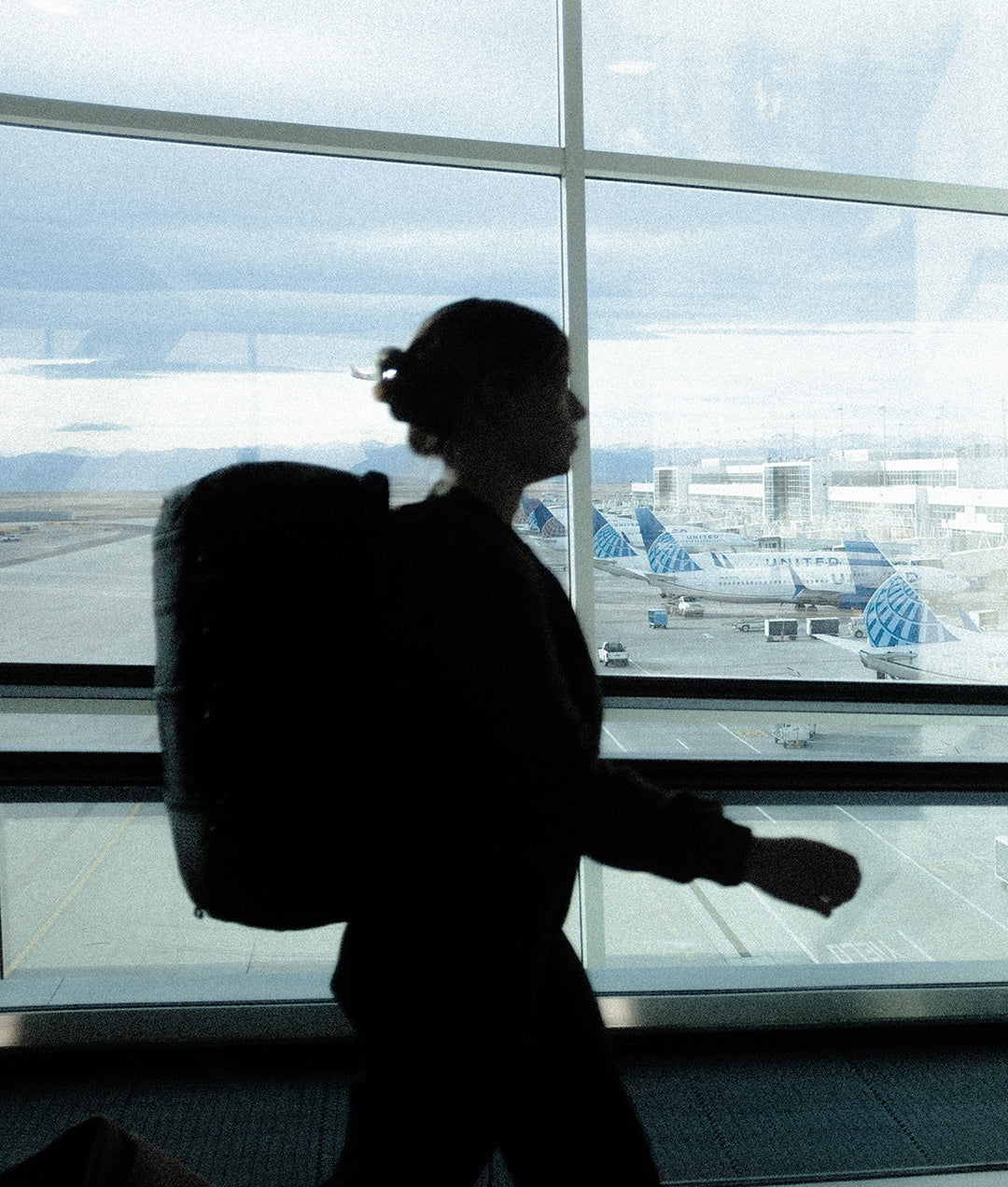 silhouette of a traveler passing through the airport with a backpack on
